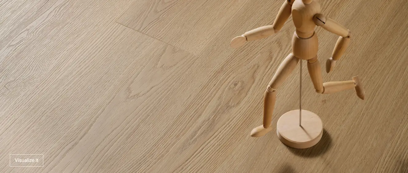 Wooden artist mannequin running on a round base, placed on a light wood floor.