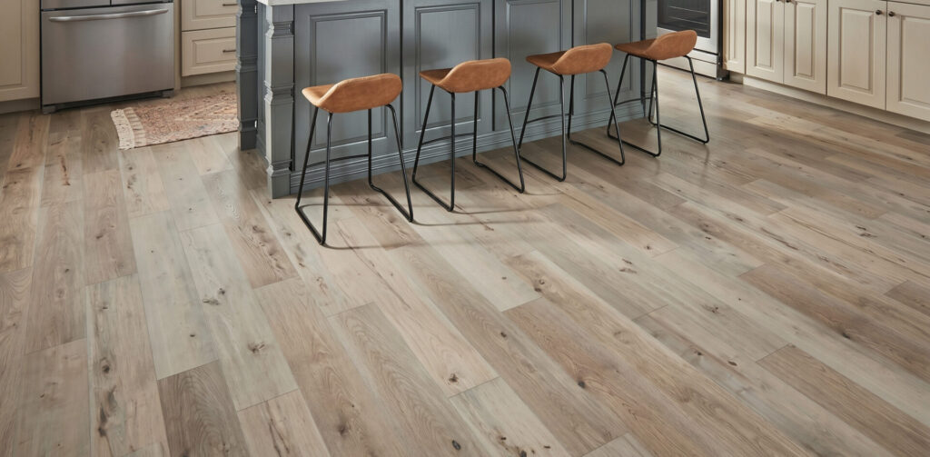 Grey-brown distressed laminate floor in a kitchen with bar stools