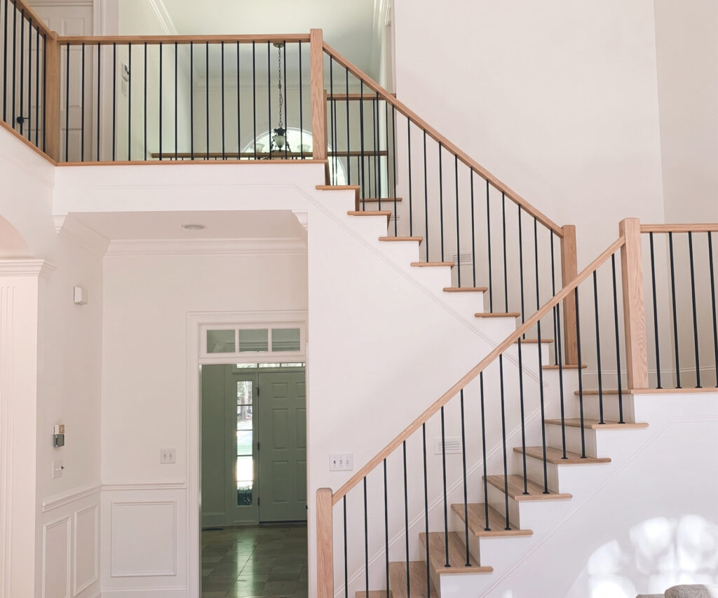 Staircase with oak treads, oak handrail and black metal spindles