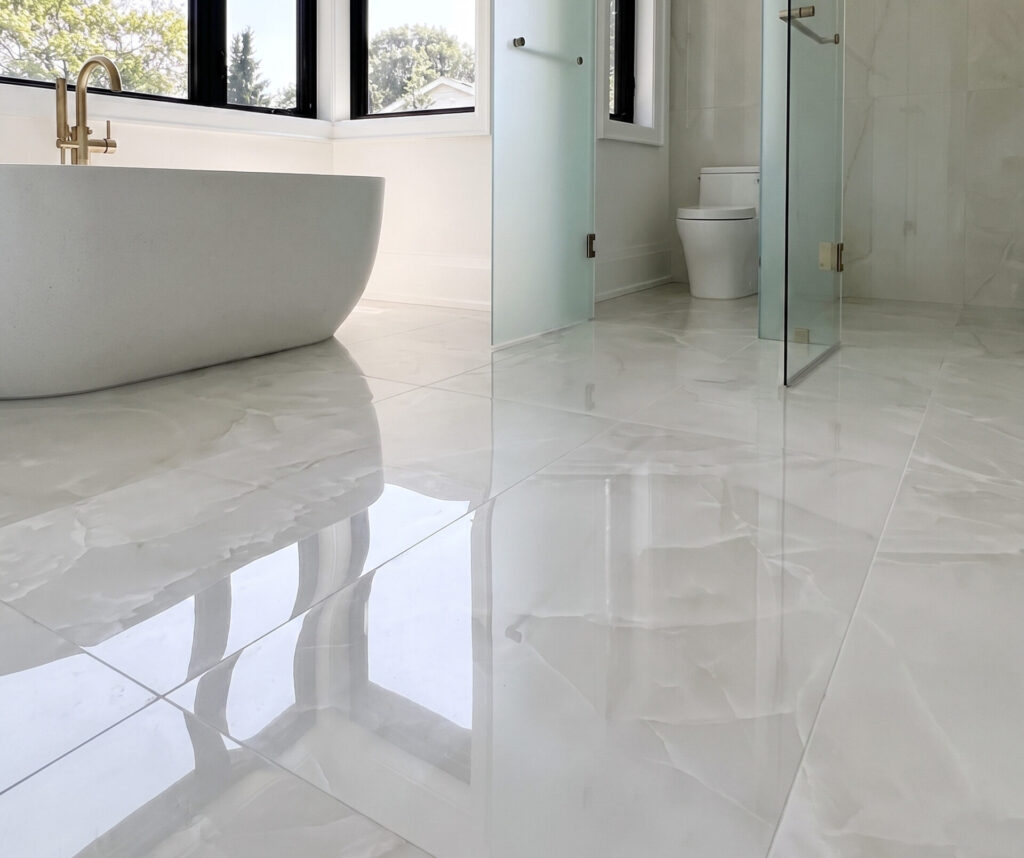 Large polished marble-look porcelain tiles in a modern bathroom
