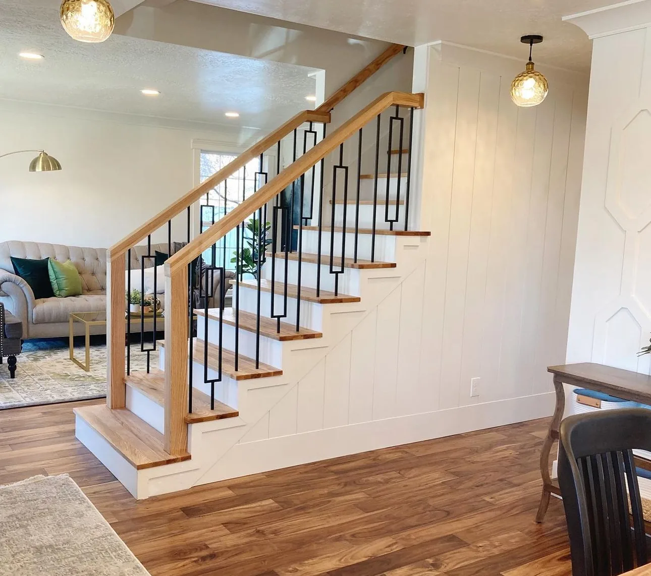 Open staircase in an East York living room with oak treads, white risers, an oak handrail, square oak newel posts and decorative black iron spindles