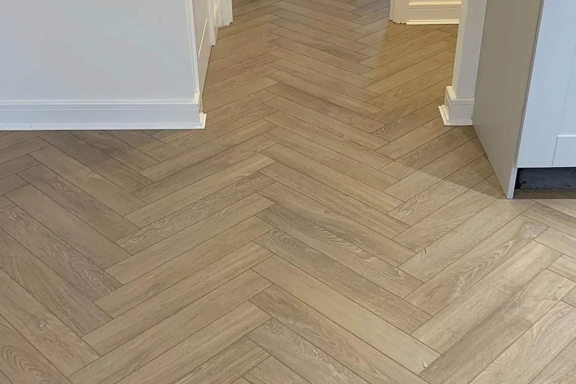Light herringbone oak floor running into a bright hallway