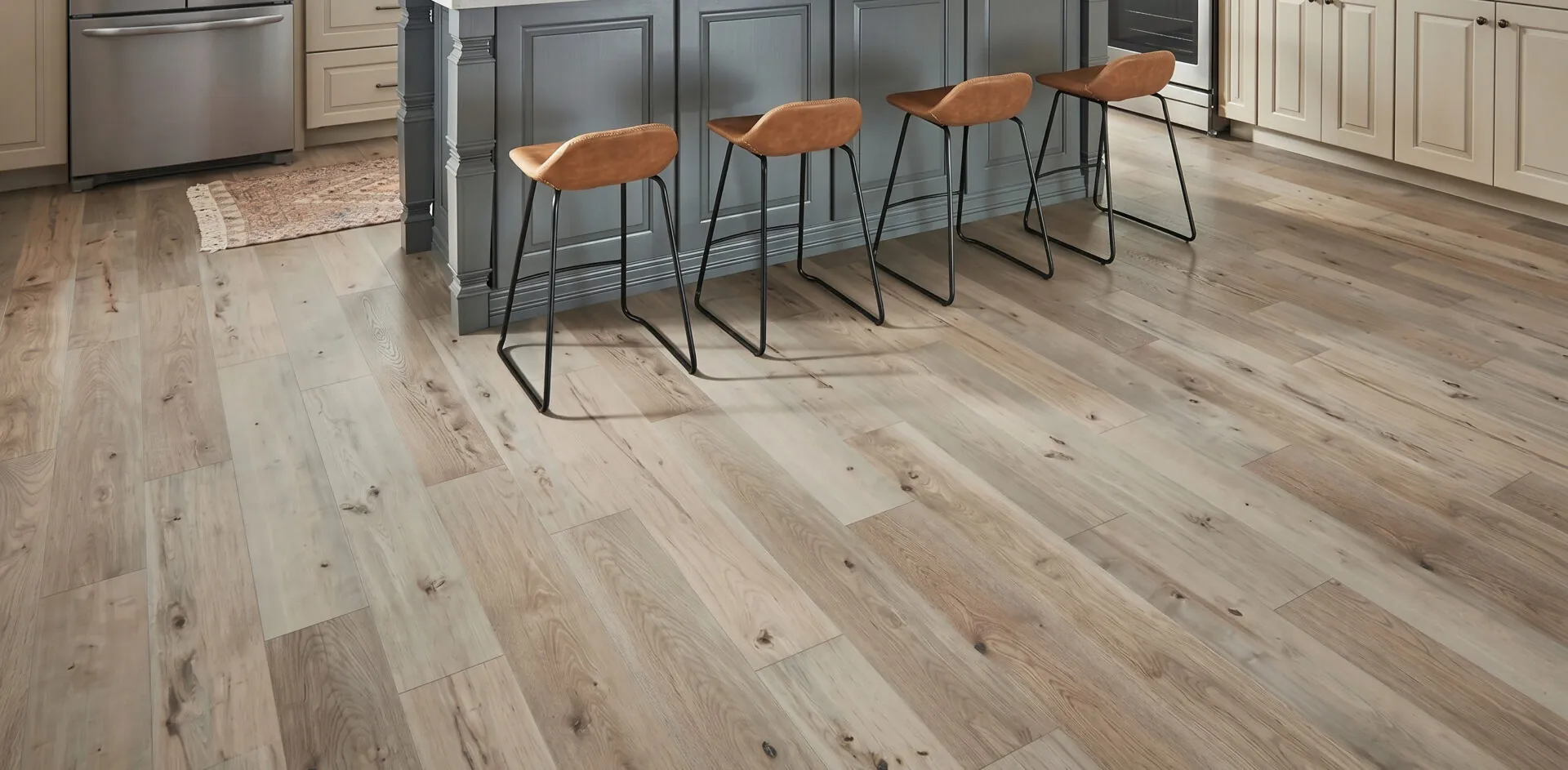 Grey-brown distressed laminate floor in a kitchen with bar stools