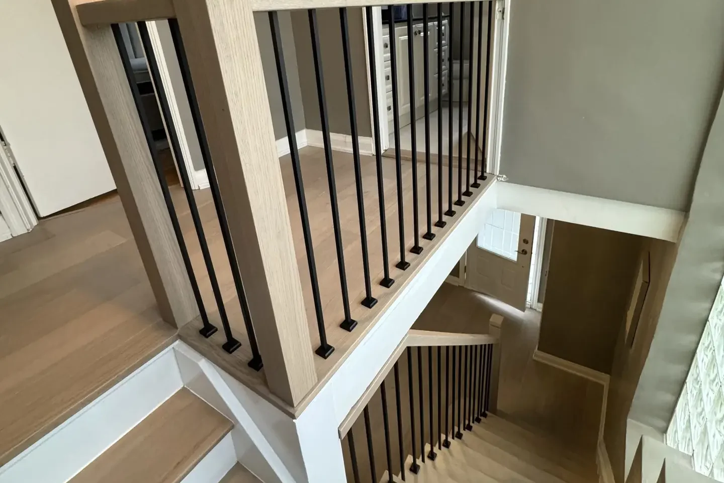 Refinished natural oak staircase and landing with black iron spindles in a Bolton home