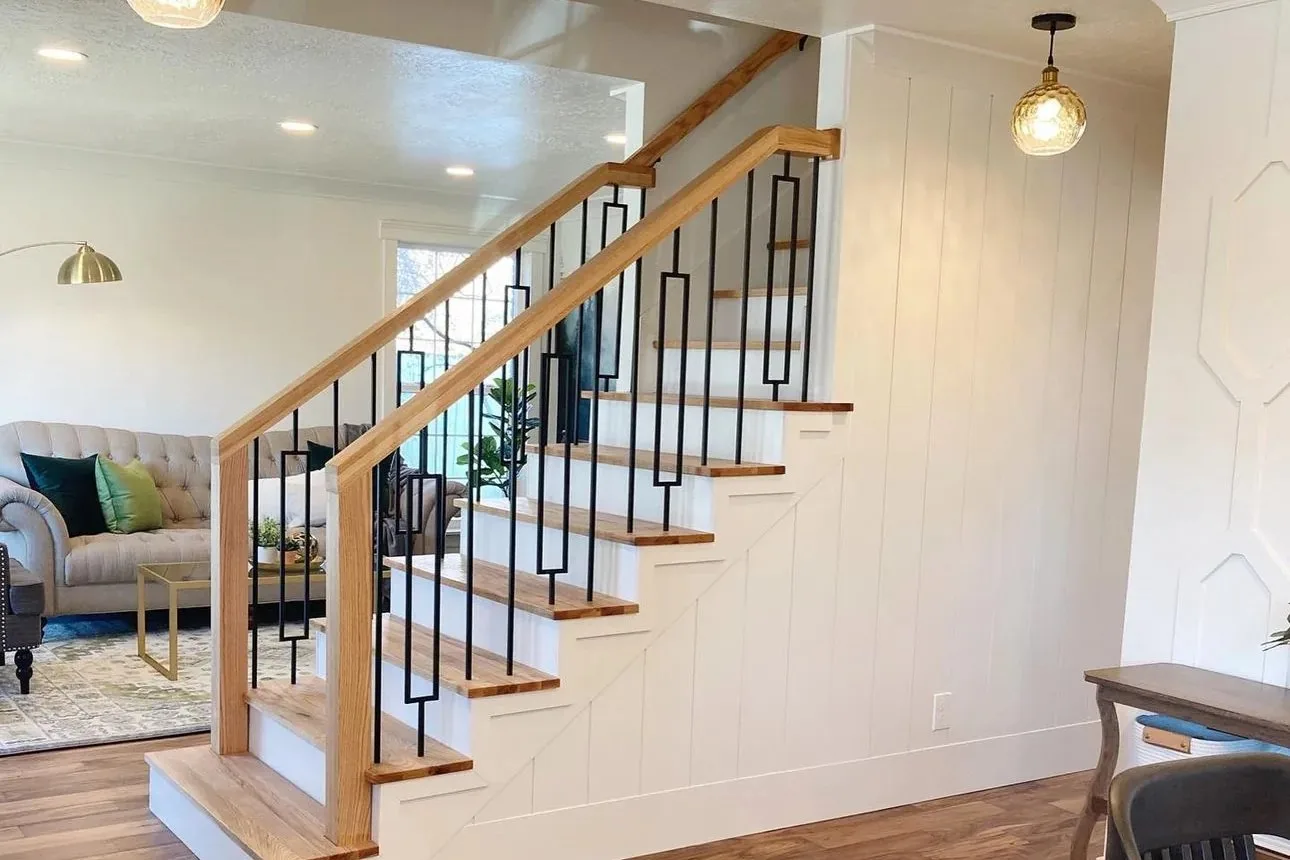 Open staircase in an East York living room with oak treads, white risers, an oak handrail and decorative black iron spindles