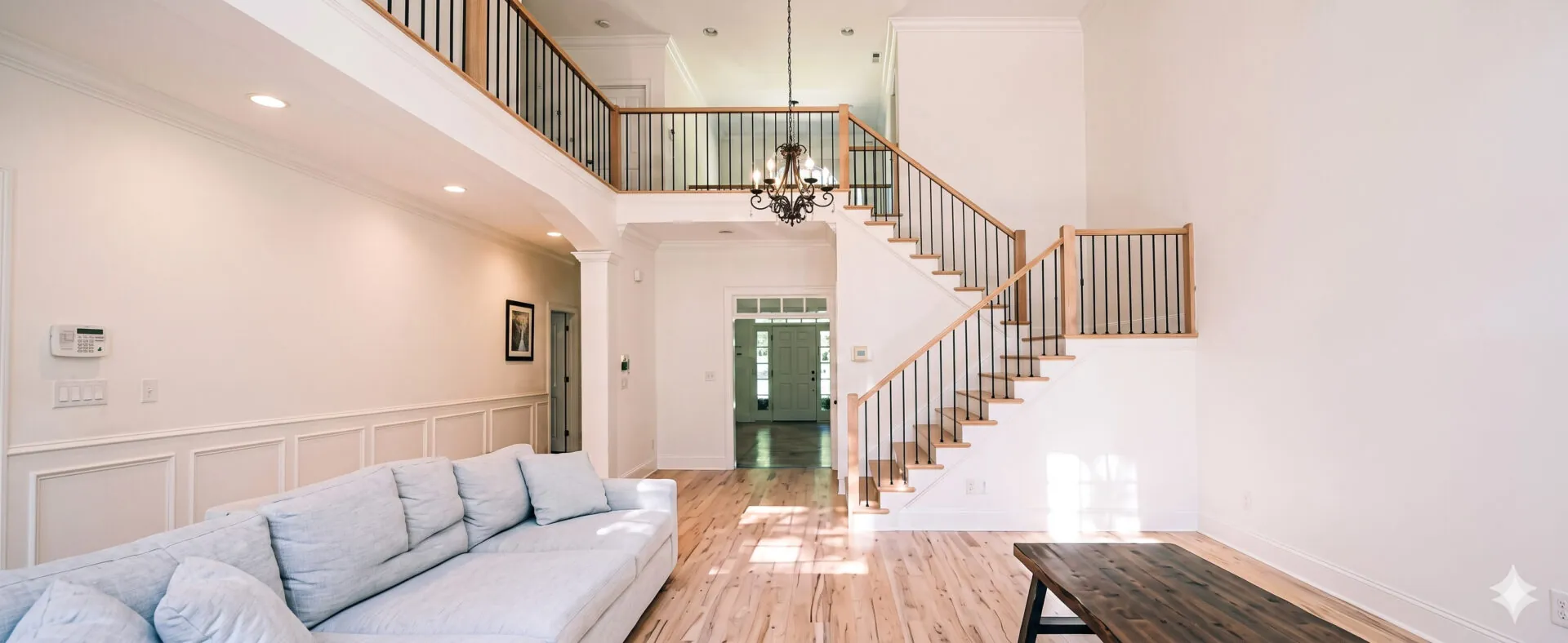 Two-storey foyer with oak floors, curved staircase and iron railings