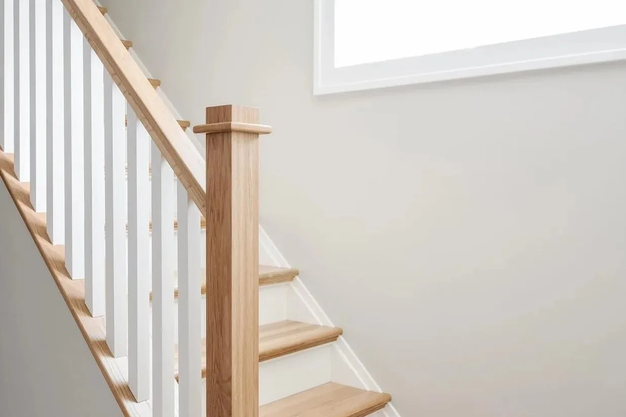 Staircase in Vaughan with light oak treads, white risers, white square spindles and an oak handrail and newel post