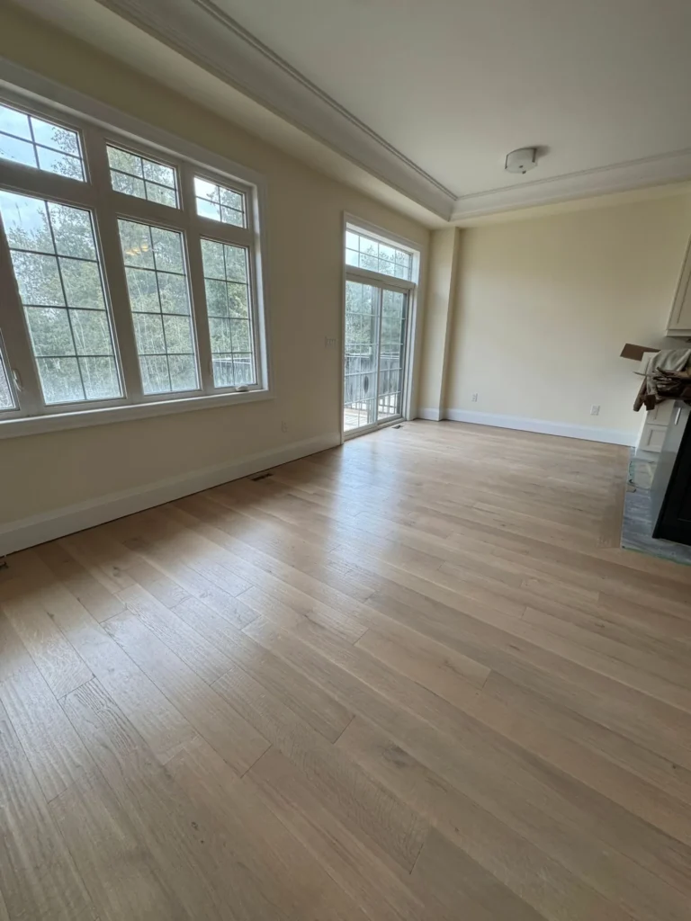 Light oak hardwood floor in a bright Toronto family room with tall windows
